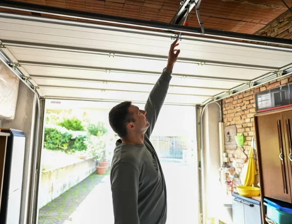 Licensed garage door company technician servicing residential overhead garage door in Garland TX