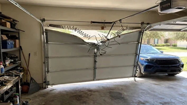 Broken torsion spring above a crooked sectional garage door in Firewheel, Garland TX